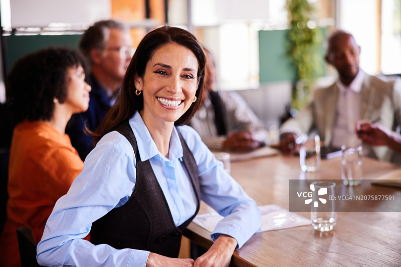 在会议室里与同事交谈的女商人图片素材