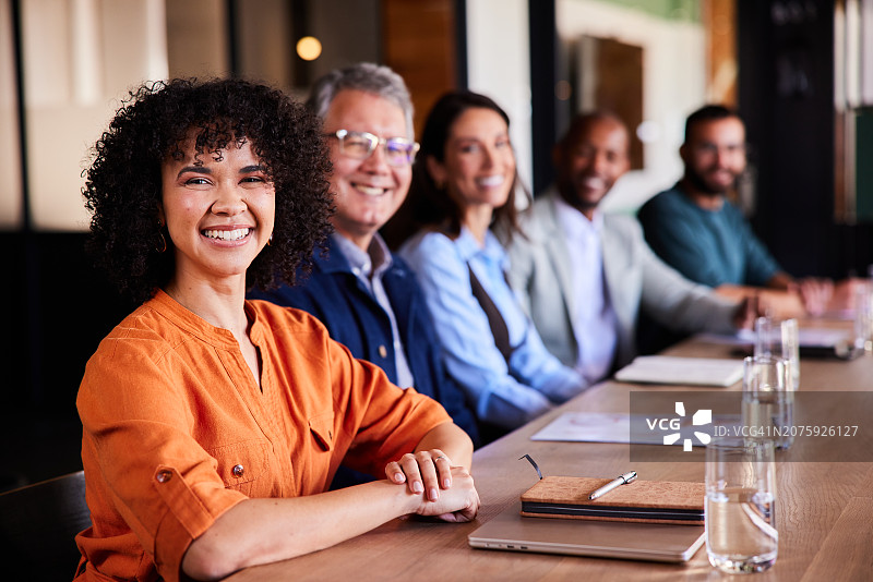 年轻女商人和一群同事在会议室里微笑图片素材