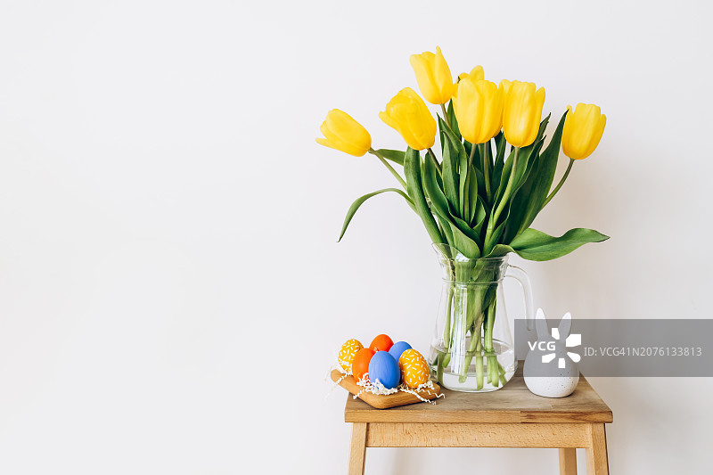 黄色郁金香、复活节兔子和彩色彩蛋静物图片素材