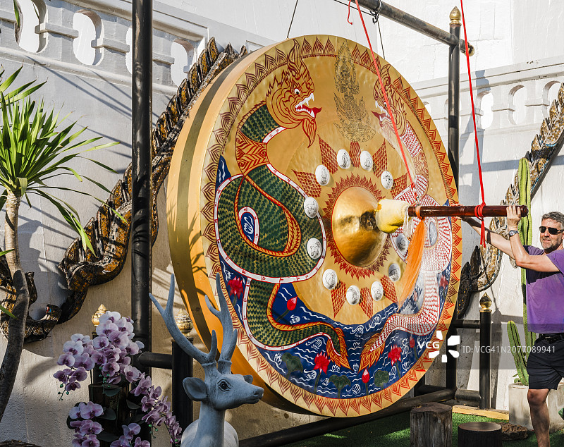 在泰国曼谷寺庙里敲锣的男人图片素材