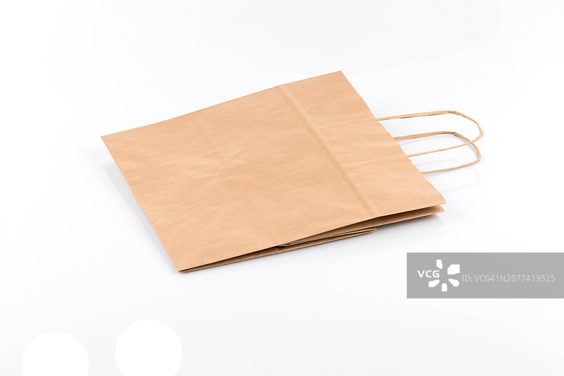 再生纸牛皮购物袋：白色背景上的包装袋图片素材