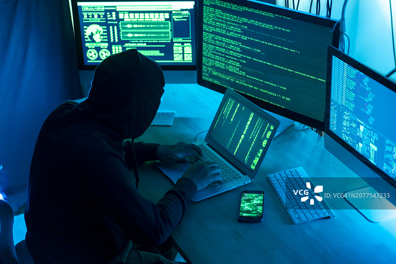 男黑客在电脑前工作。图片素材