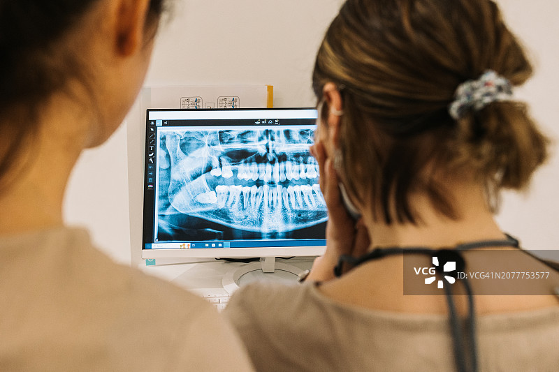 牙医评估患者的全景X光片图片素材