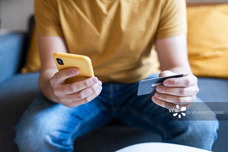 男子使用智能手机和信用卡在线购物图片素材