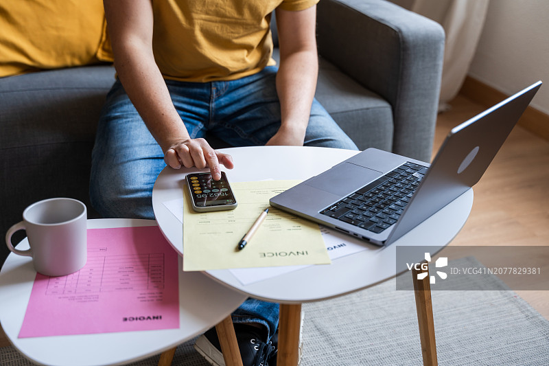 在家用计算器和笔记本电脑做预算的人图片素材