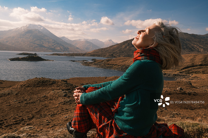 穿红色格子短裙的女人在苏格兰阔伊克湖图片素材