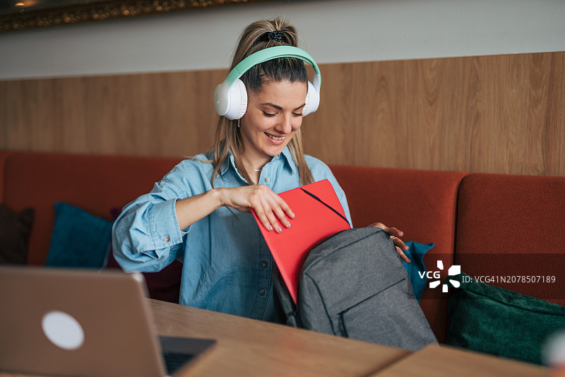 在咖啡馆整理书本的女学生图片素材
