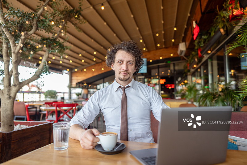在餐厅使用笔记本电脑的商人图片素材