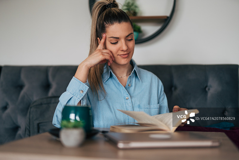 年轻女人在咖啡馆看书图片素材