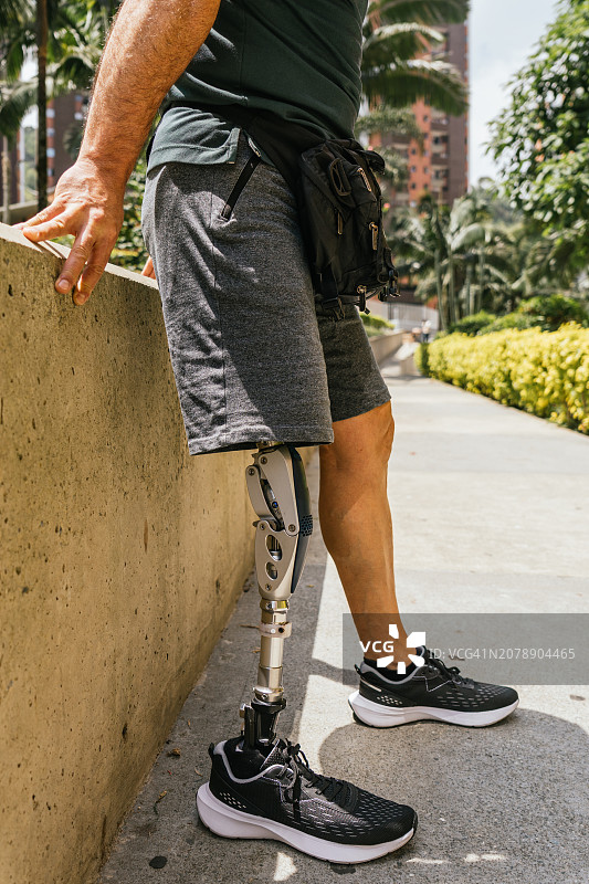 安装假肢的男人在斜坡上休息特写图片素材