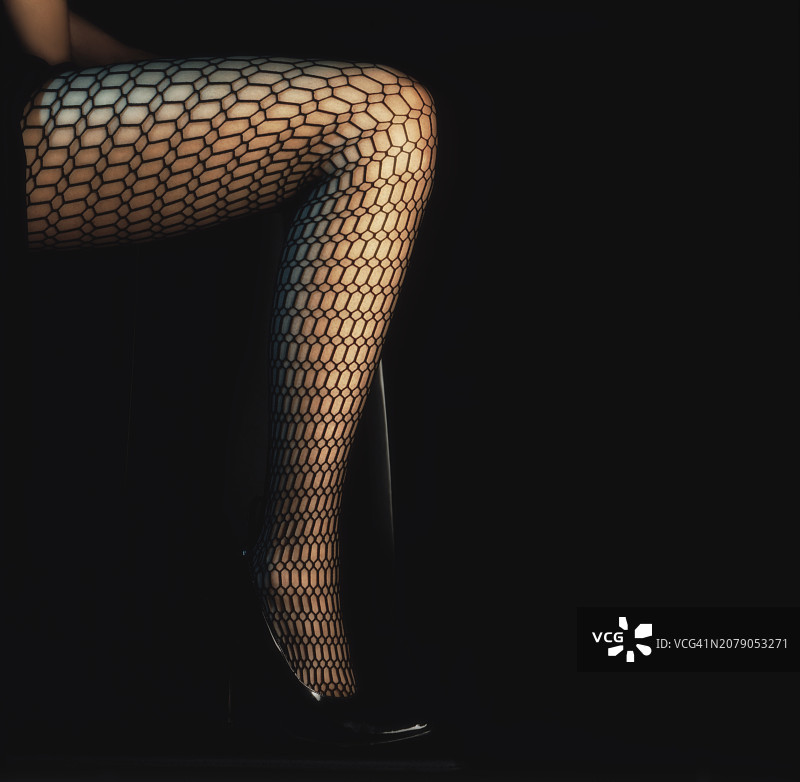女子穿长袜靠黑色背景站立的下半身照片图片素材
