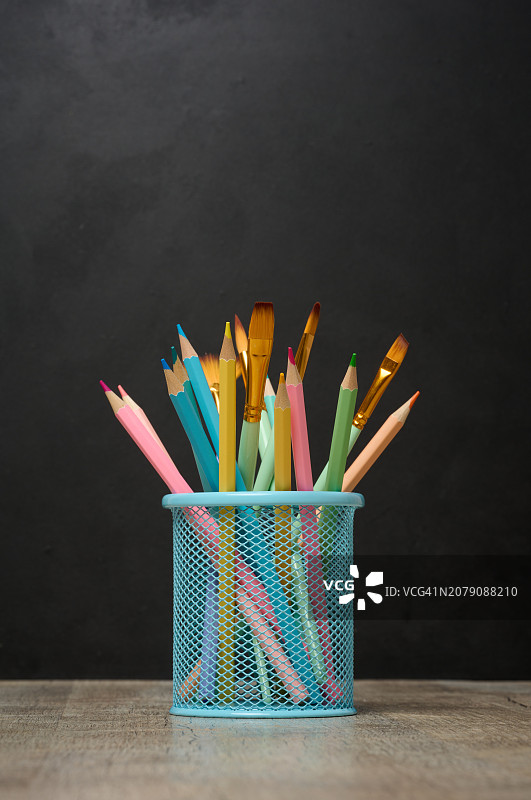 黑色背景下桌上收纳盒中彩色铅笔的特写图片素材