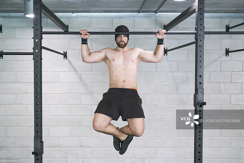 健身房里做引体向上的健壮男人图片素材