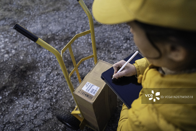 女快递员检查待交付的邮政包裹图片素材