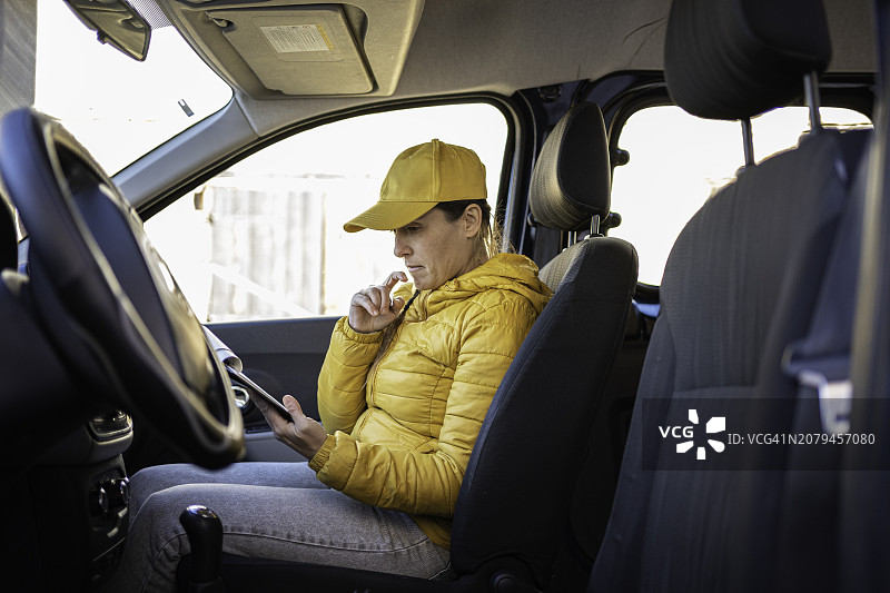 女快递员检查待交付的邮政包裹图片素材