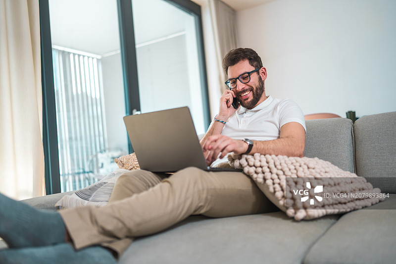 在家工作的快乐西班牙裔男投资者图片素材