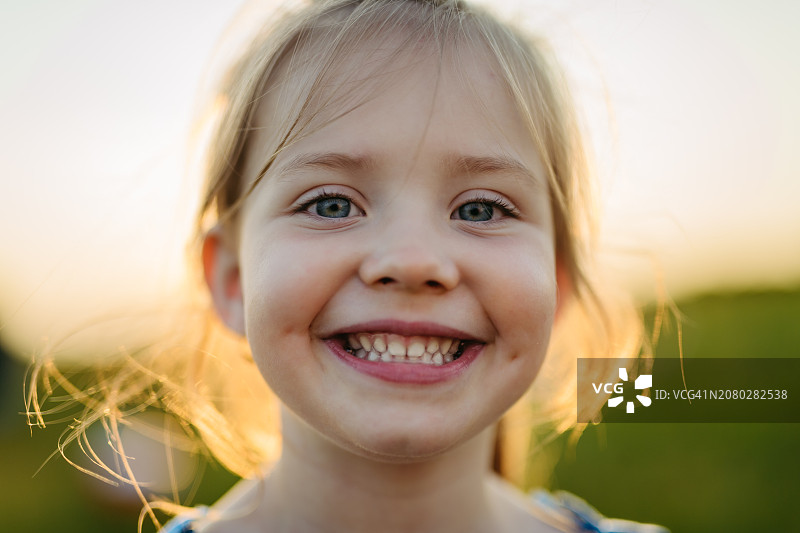 金色时段在湖边享受暑假的年轻漂亮金发女孩肖像图片素材