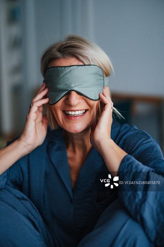 戴着睡眠面罩微笑的年长妇女肖像图片素材