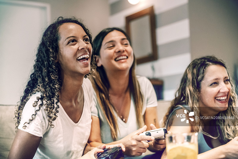 三个年轻女子一起玩电子游戏的肖像图片素材
