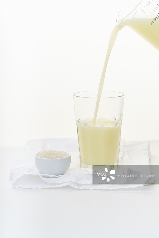 从量杯倒入玻璃杯中的米浆图片素材