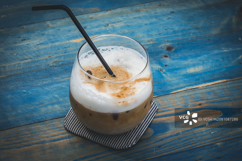 蓝色木桌上的冰拿铁图片素材