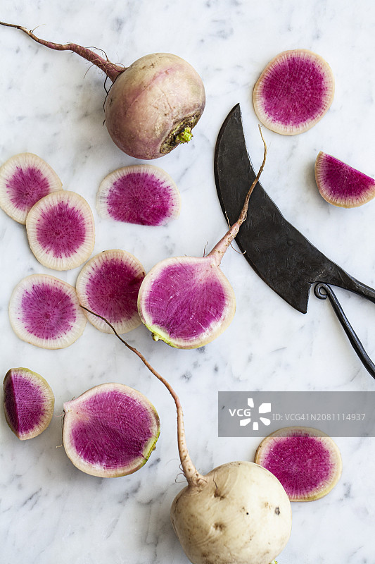 大理石台面上的萝卜切片和完整萝卜图片素材
