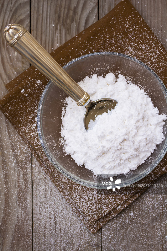 玻璃碗里的糖霜和复古勺子图片素材