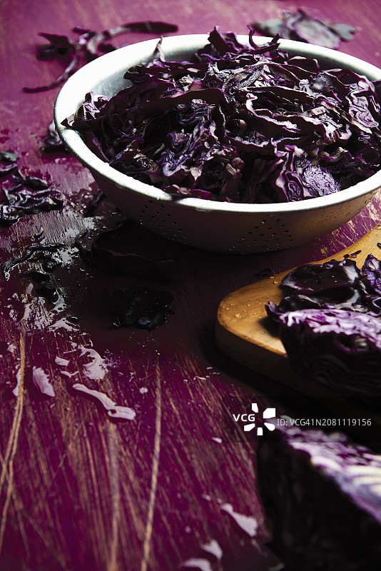 碗里和桌子上散落的红色卷心菜切片图片素材