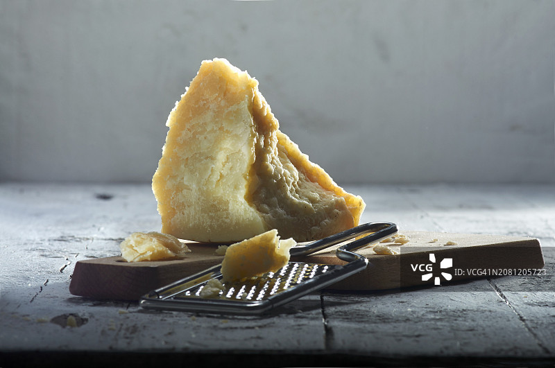 木板上的帕达诺干酪和奶酪磨碎器图片素材