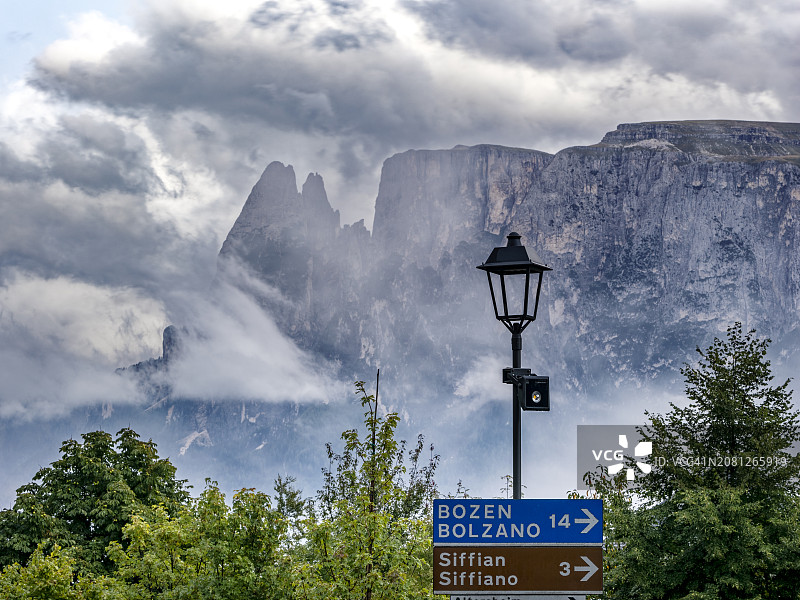 意大利多洛米蒂阿尔卑斯山大型岩石山脉旁边的街灯和路标图片素材