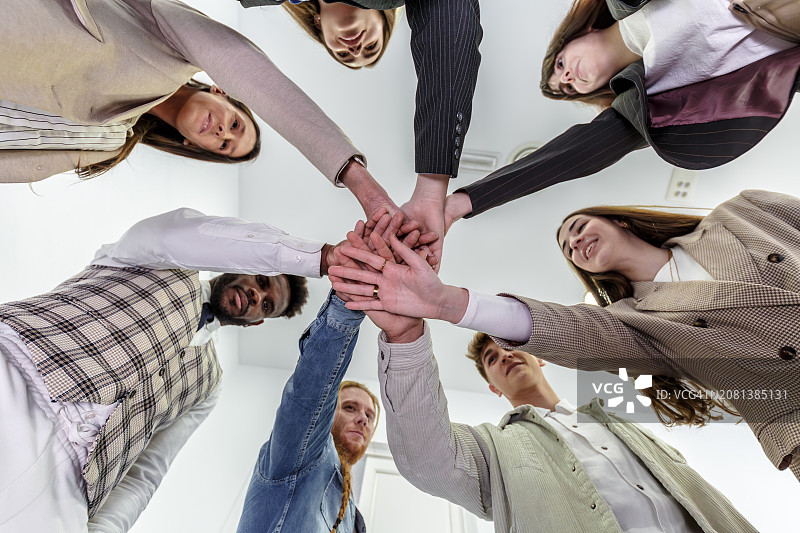 办公室工作人员手拉手，展示团队团结与协作图片素材