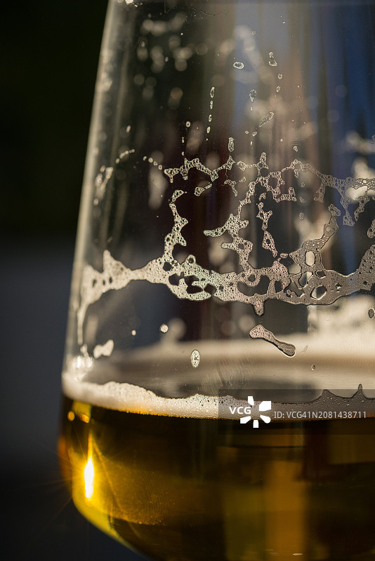 有啤酒和剩余啤酒泡沫的玻璃杯图片素材