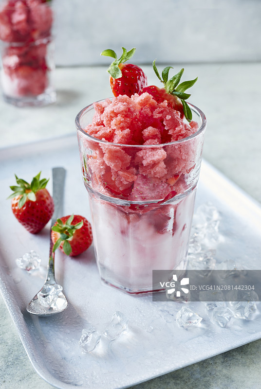 鸡尾酒杯中的草莓冰沙，配新鲜草莓和冰块图片素材
