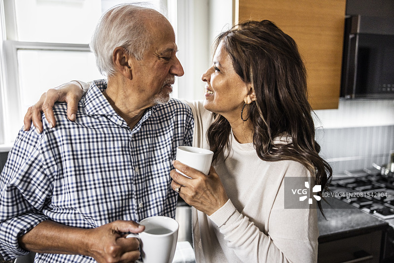 老年夫妇在厨房里喝咖啡聊天，欢声笑语图片素材