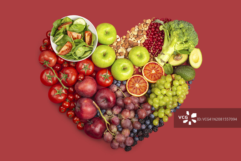 红色背景中呈心形的各色蔬菜、水果和坚果（带剪切路径）图片素材