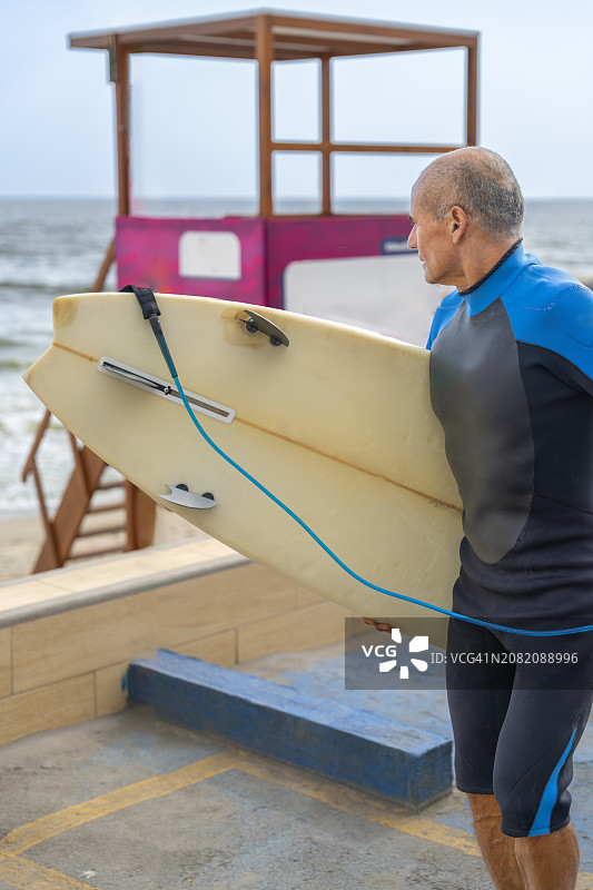 成年冲浪者携带冲浪板走向大海图片素材