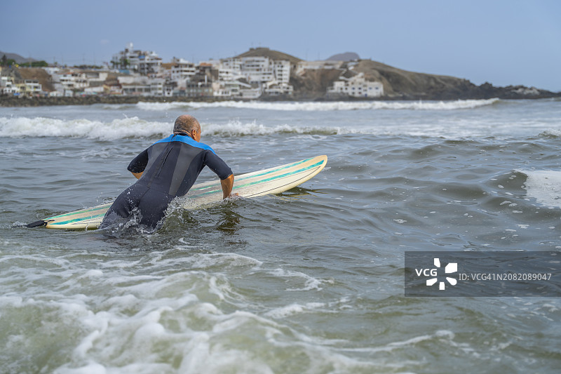 中年冲浪者在太平洋上冲浪图片素材