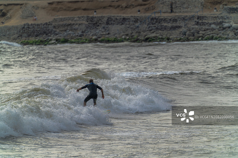 成年人在黄昏时享受冲浪图片素材