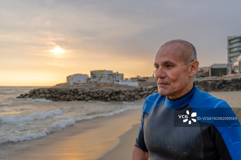日落后在岸边冲浪的老年人图片素材