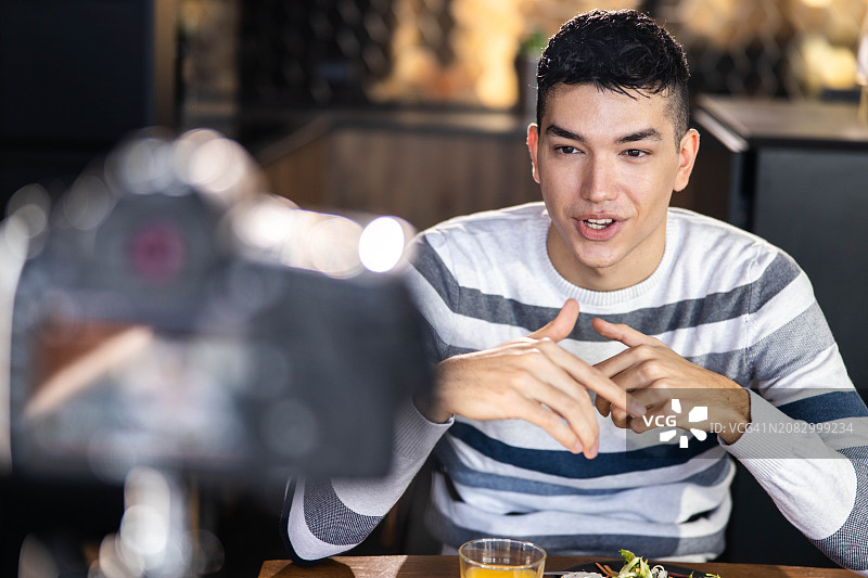 快乐的男人在家通过相机拍摄视频博客图片素材