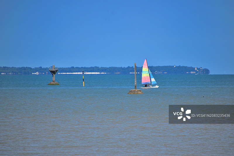 博瓦苏梅尔：小帆船从 passage du Gois 的信标附近经过，背景是努瓦尔穆捷岛图片素材