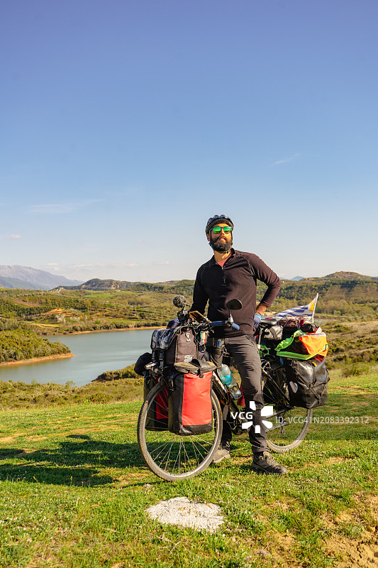 旅程开始：中年自行车手准备在风景如画的户外进行自行车旅行图片素材