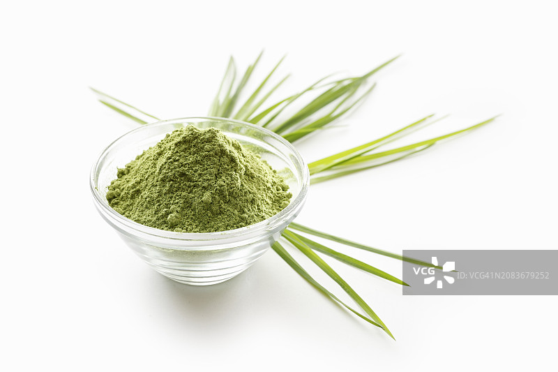 白色表面玻璃碗里的小麦草粉图片素材