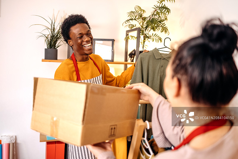 挑选衣服以完成客户订单的年轻人图片素材