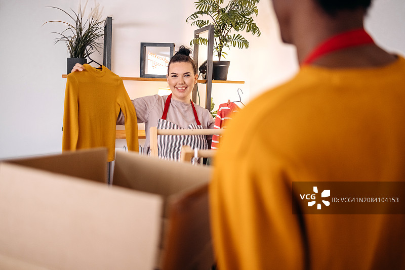 挑选衣服以完成客户订单的年轻人图片素材