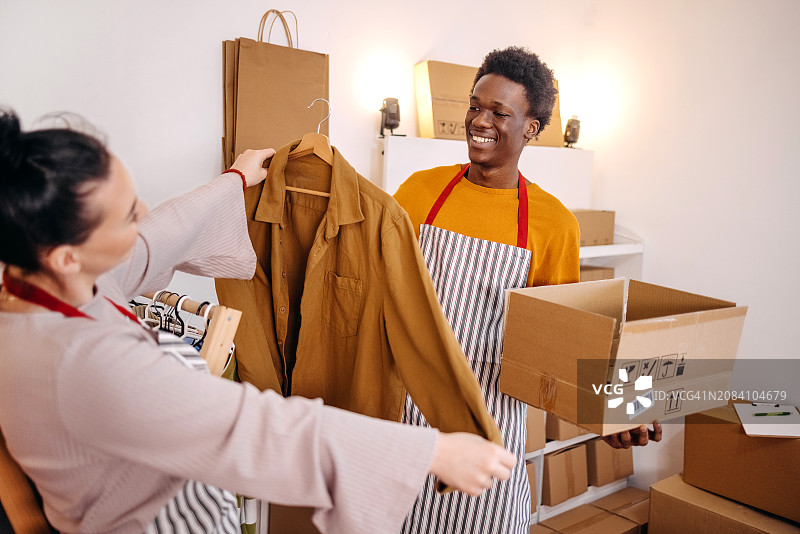 挑选衣服以完成客户订单的年轻人图片素材