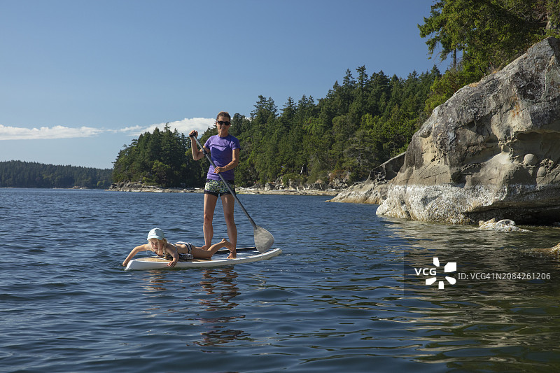 夏季假期：年轻女孩和母亲在太平洋上进行立式划桨图片素材