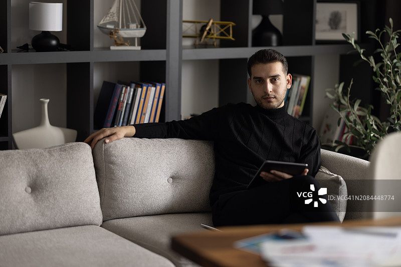 年轻商人居家办公时使用数码平板电脑图片素材