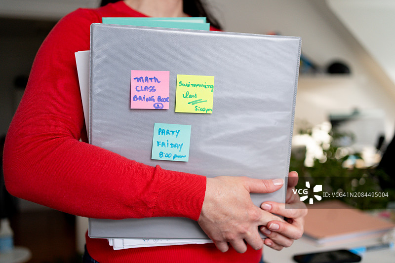 女人手拿学习用品和便利贴图片素材