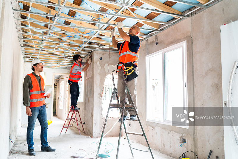 装修中安装天花板和窗户的建筑工人图片素材
